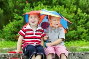 12374471-two-funny-kids-friends-sitting-under-umbrella-outdoor-summer--spring-season